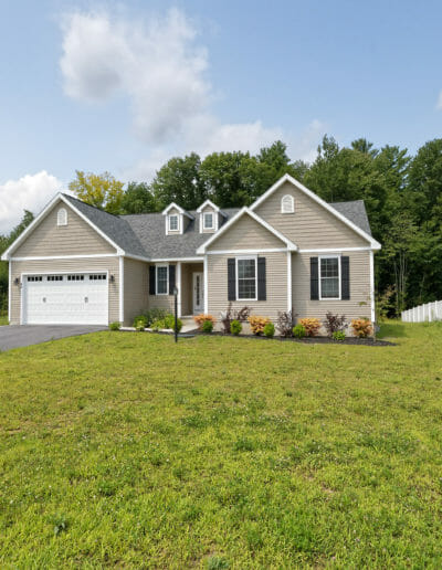 exterior of a new construction home with tan siding and a white garage door