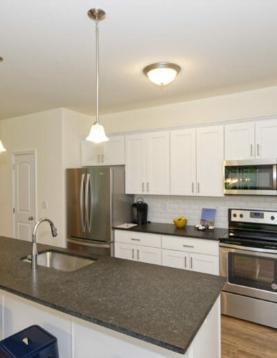 modern kitchen with an island, stone countertops, and stainless steel appliances