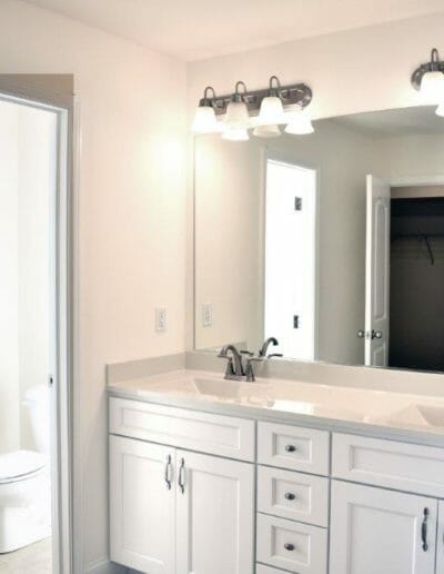 new bathroom with double sinks and white cabinets