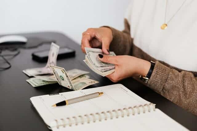 Woman counting money while sitting at the desk