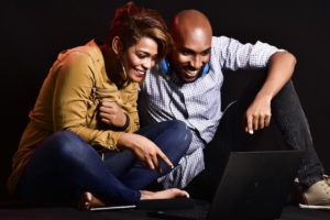 A happy couple looking at a laptop.