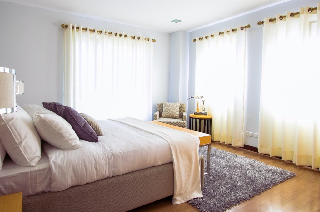 bedroom with bed and windows and curtains