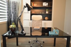 A home office equipped with a desk, a chair, and some shelving