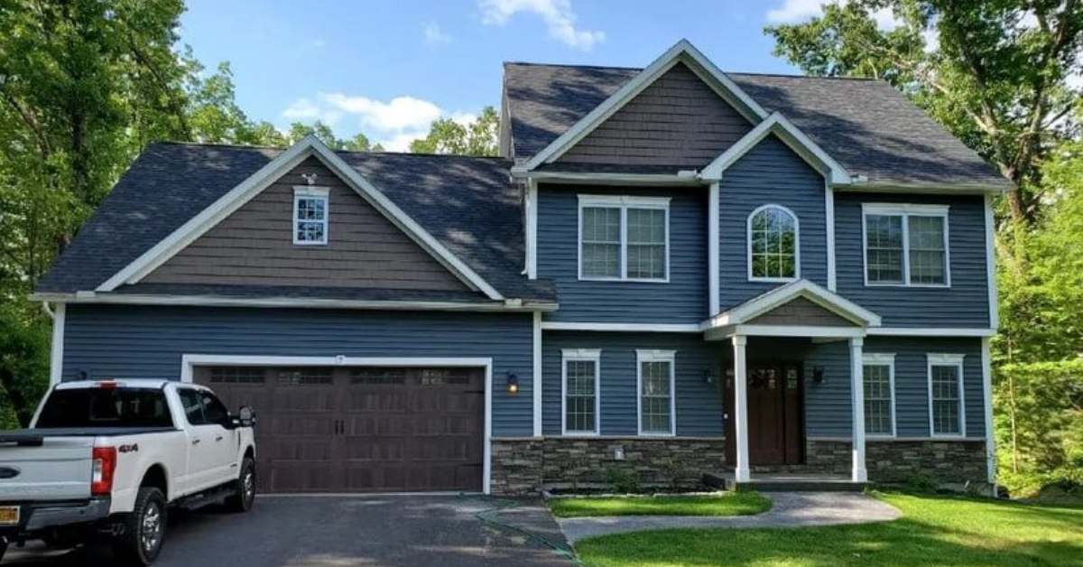 a blue house with a white truck in the driveway