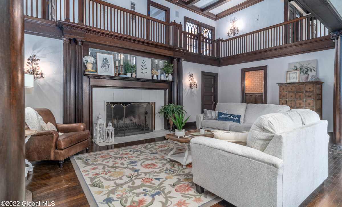 a large living room with a fireplace and chairs