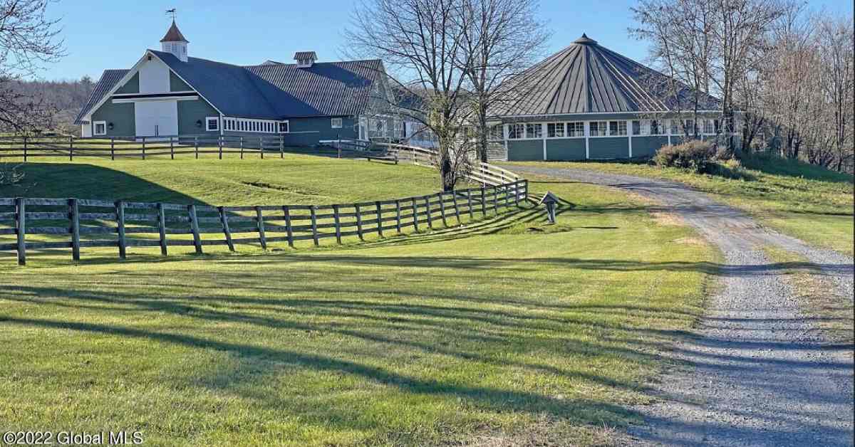 large equestrian estate with fenced in area and homes