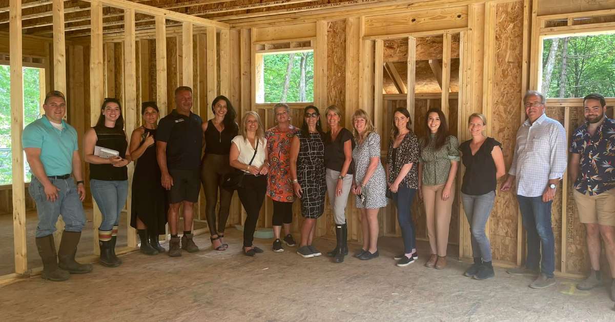 group poses in home partially under construction