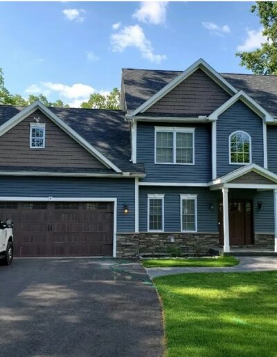 exterior of home in blue siding with stone accents