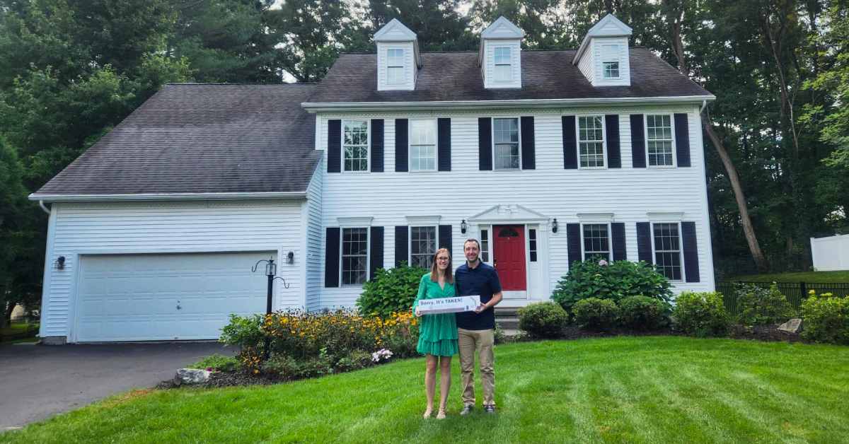 happy couple with front of a new house