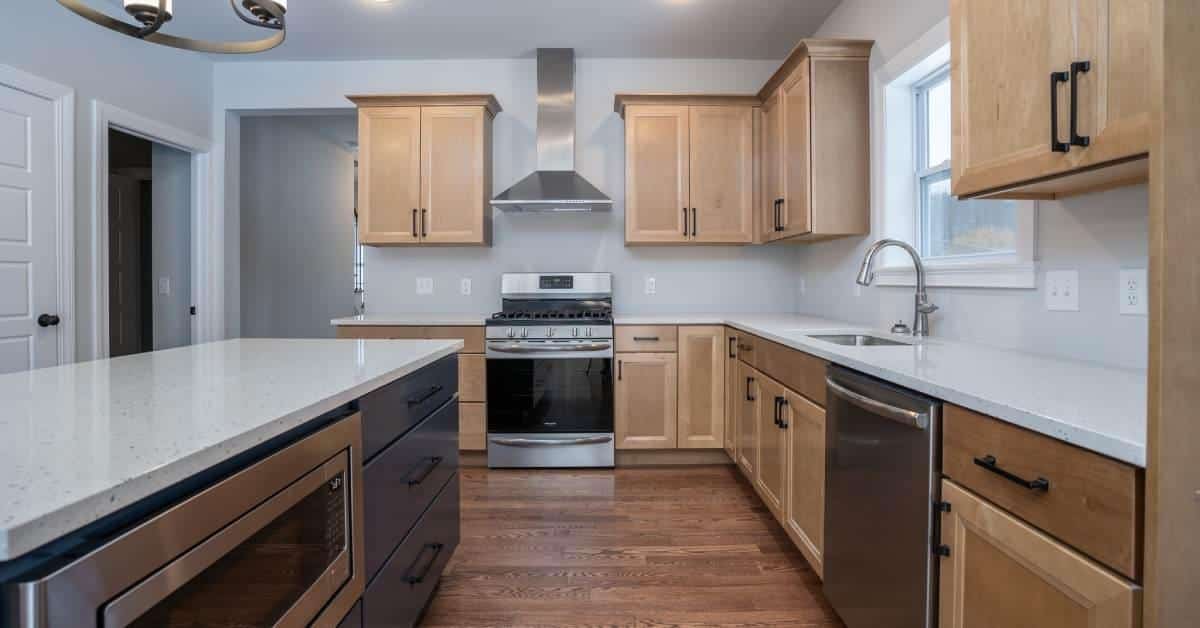 large kitchen with wooden cabinets, wood floor, and steel appliances