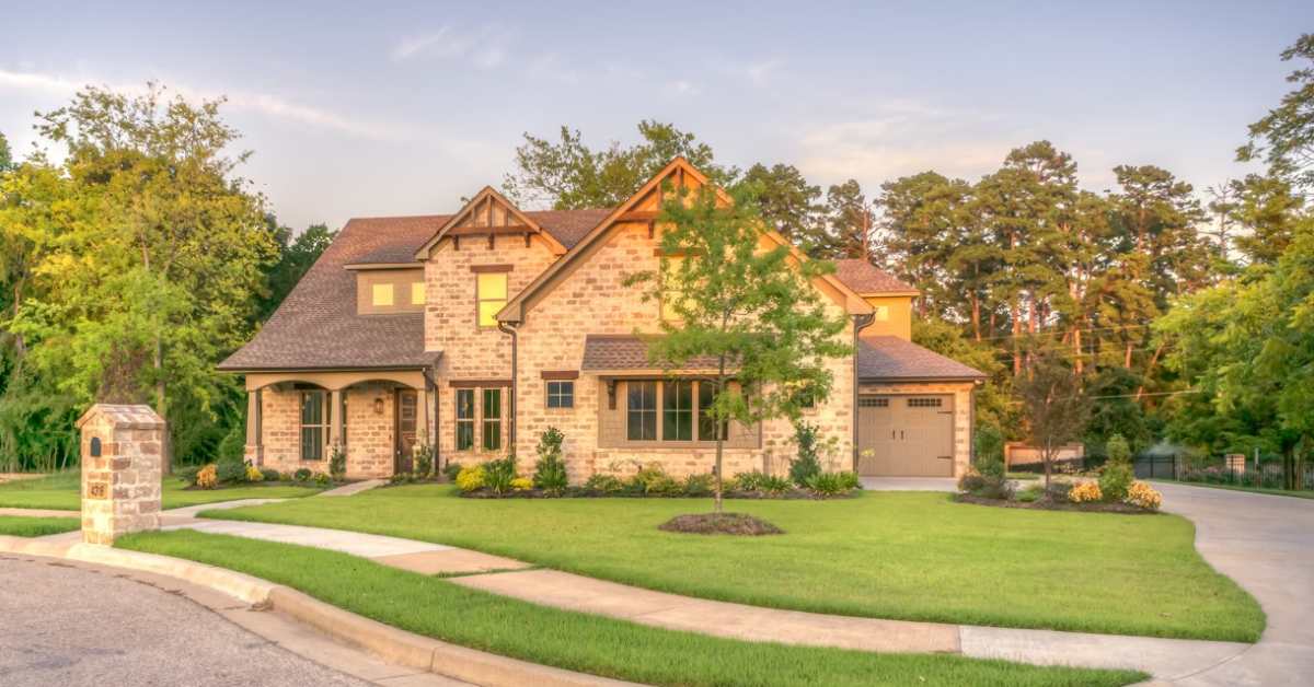 exterior of a luxury home and a grassy lawn