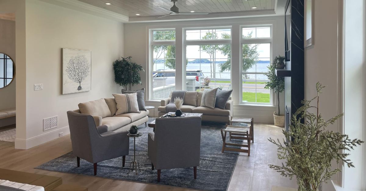 a spacious living room with furniture and large glass windows