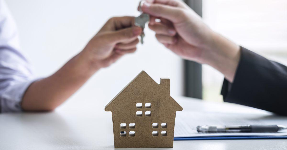 handing keys over above a small house icon