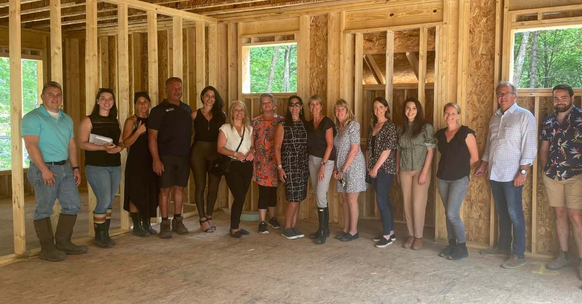 a group of people standing inside a house frame