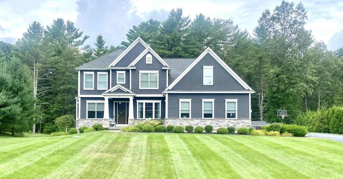 a well trimmed front lawn and a house