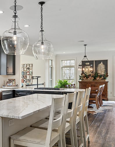 kitchen with white countertops and dining room behind it
